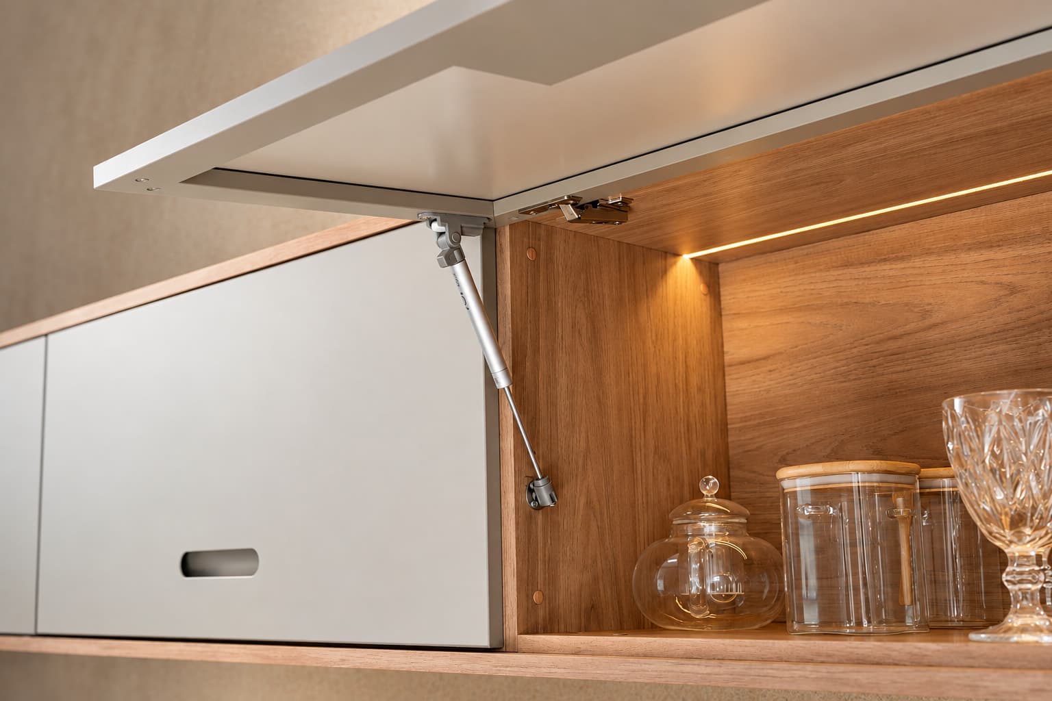 Armário aéreo com porta basculante aberta e iluminação em LED no interior amadeirado